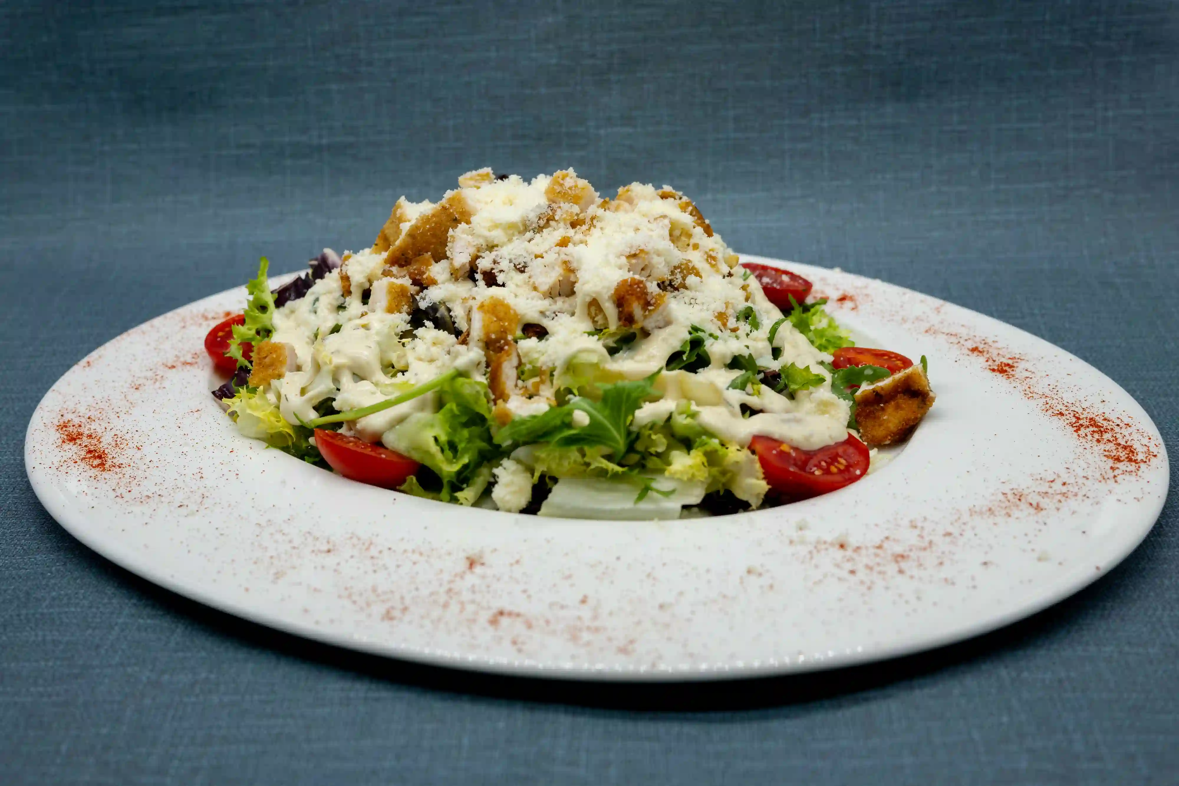 Ensalada César con pollo crujiente, lascas de parmesano y salsa